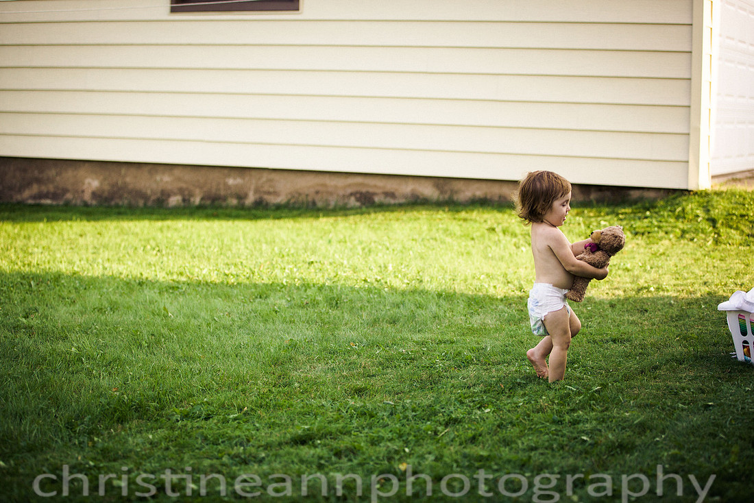 Duluth MN Lifestyle Family Session with a beloved teddy bear, apple tree, apples, sleepy kids, balloons, lawnmower, siblings, diaper, laundry, mom, dad - all outdoors in the back yard of their home.