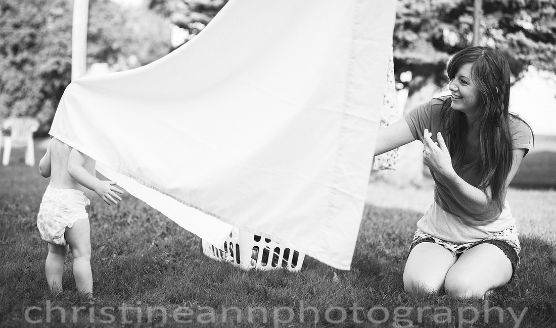 Duluth MN Lifestyle Family Session with a beloved teddy bear, apple tree, apples, sleepy kids, balloons, lawnmower, siblings, diaper, laundry, mom, dad - all outdoors in the back yard of their home.