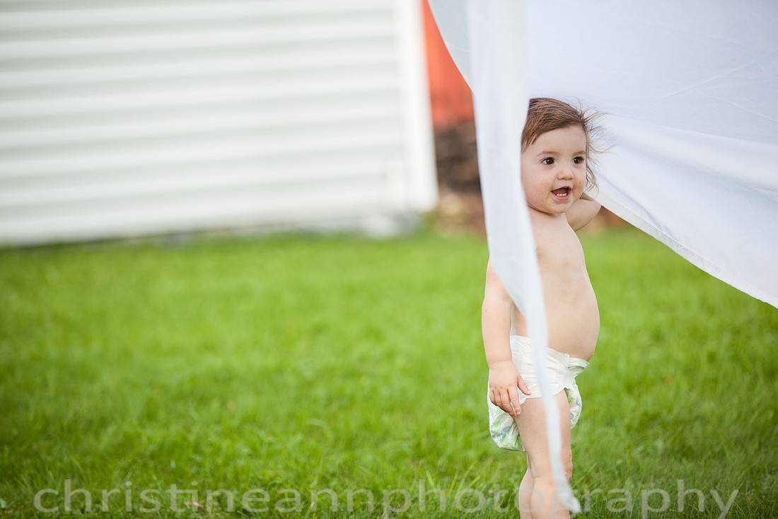 Duluth MN Lifestyle Family Session with a beloved teddy bear, apple tree, apples, sleepy kids, balloons, lawnmower, siblings, diaper, laundry, mom, dad - all outdoors in the back yard of their home.