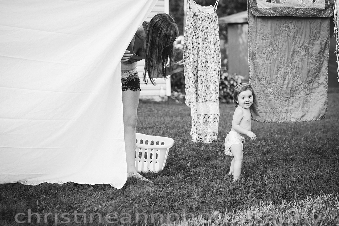 Duluth MN Lifestyle Family Session with a beloved teddy bear, apple tree, apples, sleepy kids, balloons, lawnmower, siblings, diaper, laundry, mom, dad - all outdoors in the back yard of their home.