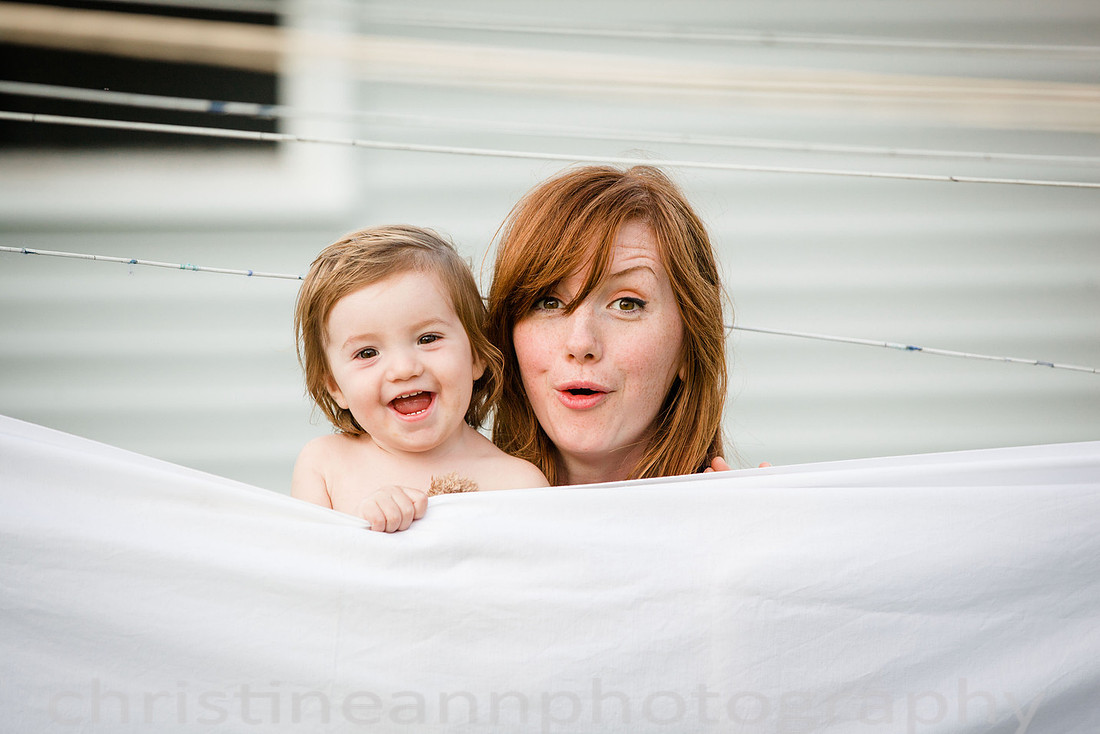 Duluth MN Lifestyle Family Session with a beloved teddy bear, apple tree, apples, sleepy kids, balloons, lawnmower, siblings, diaper, laundry, mom, dad - all outdoors in the back yard of their home.