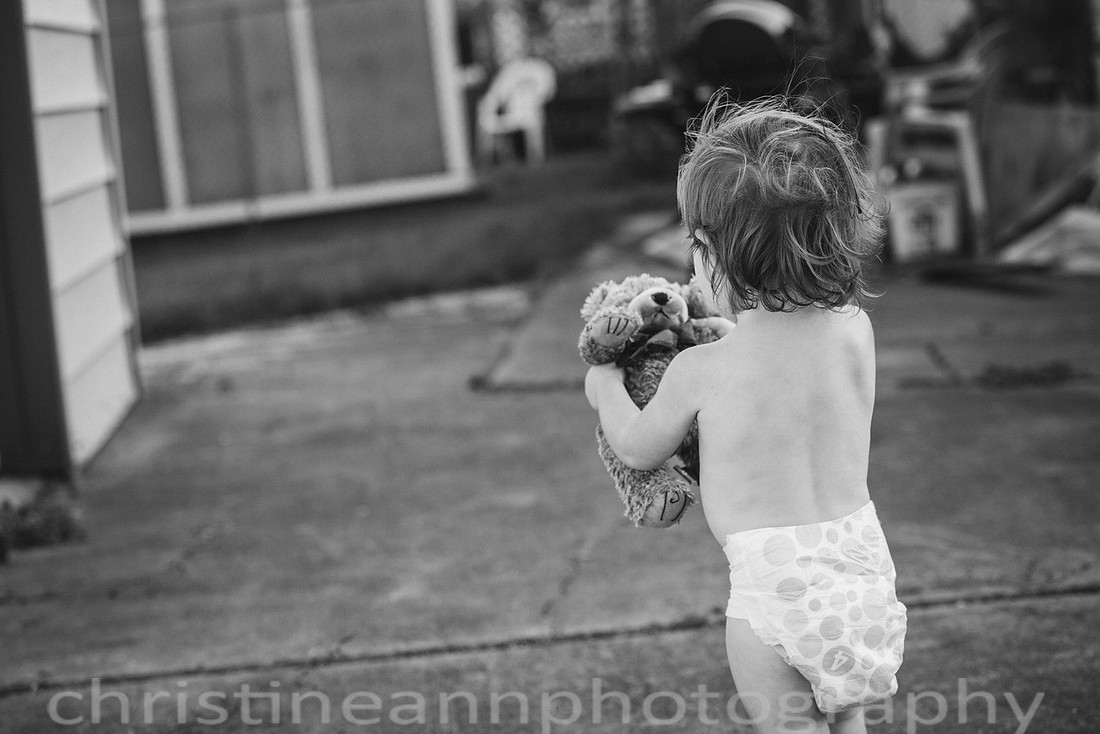 Duluth MN Lifestyle Family Session with a beloved teddy bear, apple tree, apples, sleepy kids, balloons, lawnmower, siblings, diaper, laundry, mom, dad - all outdoors in the back yard of their home.