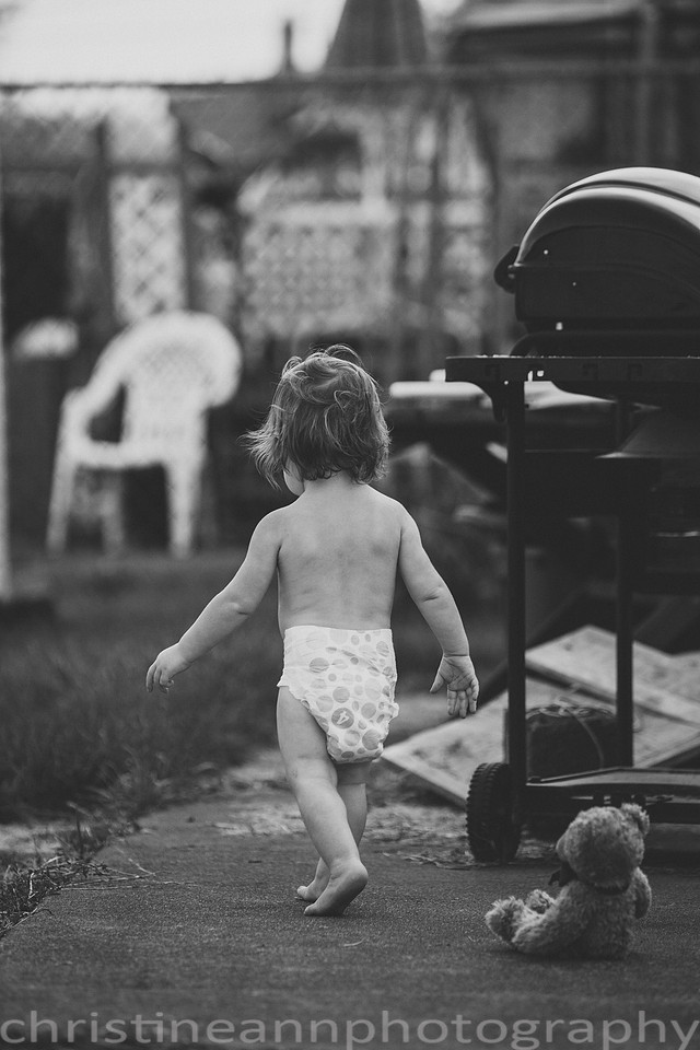 Duluth MN Lifestyle Family Session with a beloved teddy bear, apple tree, apples, sleepy kids, balloons, lawnmower, siblings, diaper, laundry, mom, dad - all outdoors in the back yard of their home.