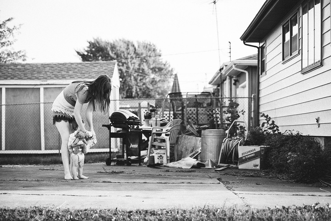 Duluth MN Lifestyle Family Session with a beloved teddy bear, apple tree, apples, sleepy kids, balloons, lawnmower, siblings, diaper, laundry, mom, dad - all outdoors in the back yard of their home.
