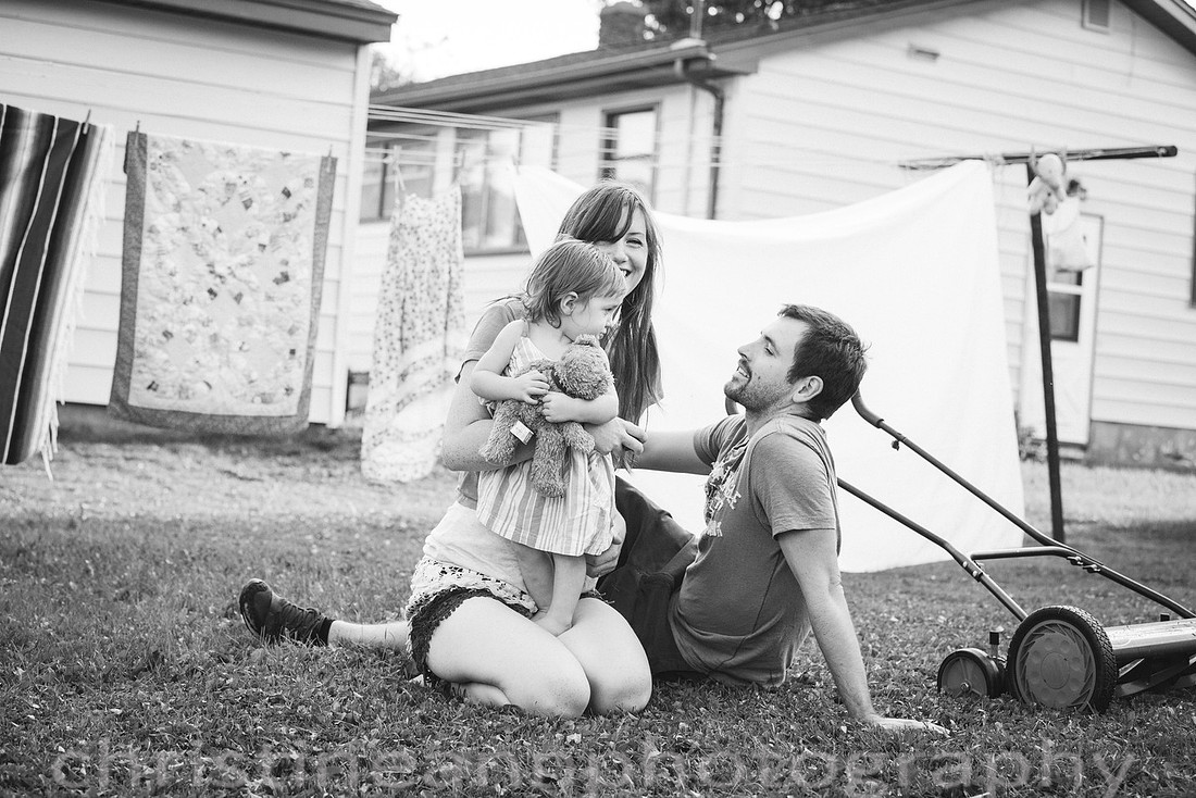 Duluth MN Lifestyle Family Session with a beloved teddy bear, apple tree, apples, sleepy kids, balloons, lawnmower, siblings, diaper, laundry, mom, dad - all outdoors in the back yard of their home.
