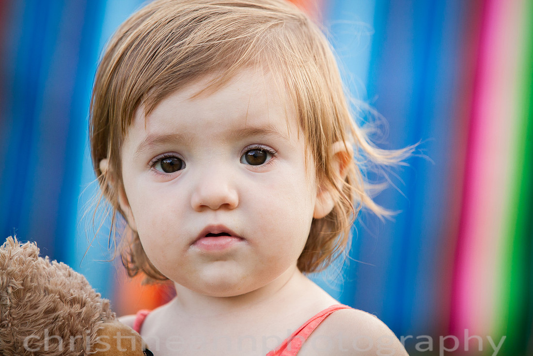 Duluth MN Lifestyle Family Session with a beloved teddy bear, apple tree, apples, sleepy kids, balloons, lawnmower, siblings, diaper, laundry, mom, dad - all outdoors in the back yard of their home.