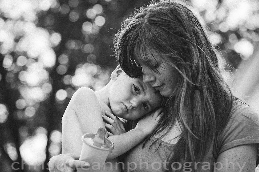 Duluth MN Lifestyle Family Session with a beloved teddy bear, apple tree, apples, sleepy kids, balloons, lawnmower, siblings, diaper, laundry, mom, dad - all outdoors in the back yard of their home.