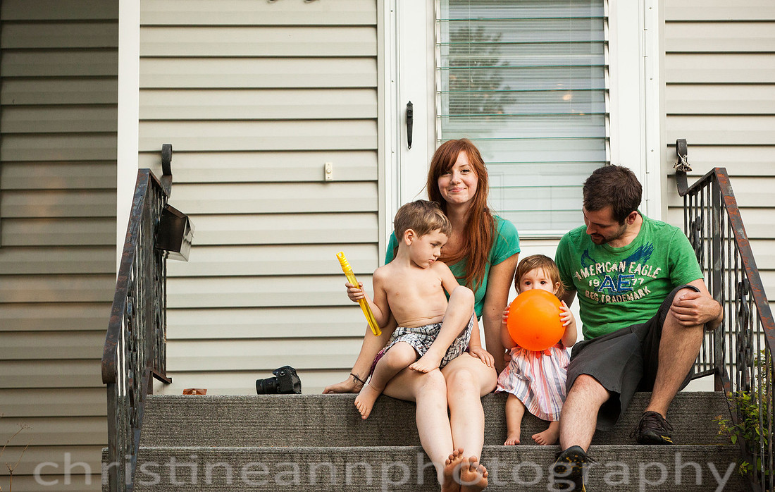 Duluth MN Lifestyle Family Session with a beloved teddy bear, apple tree, apples, sleepy kids, balloons, lawnmower, siblings, diaper, laundry, mom, dad - all outdoors in the back yard of their home.