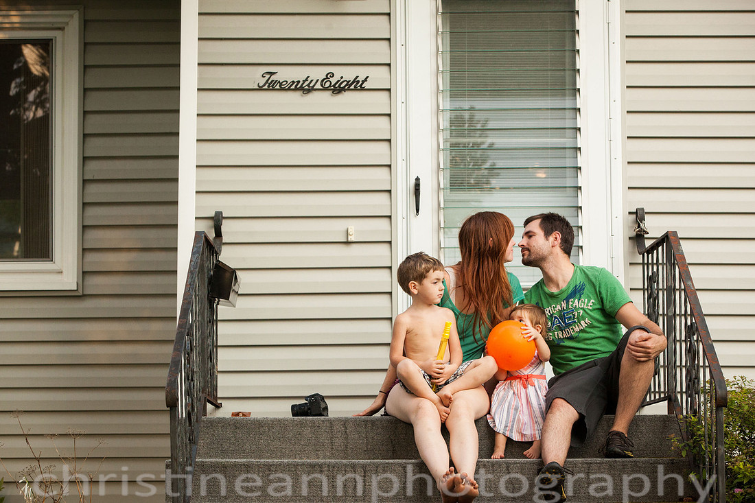 Duluth MN Lifestyle Family Session with a beloved teddy bear, apple tree, apples, sleepy kids, balloons, lawnmower, siblings, diaper, laundry, mom, dad - all outdoors in the back yard of their home.