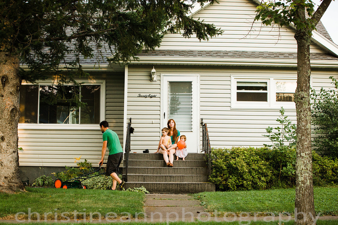 Duluth MN Lifestyle Family Session with a beloved teddy bear, apple tree, apples, sleepy kids, balloons, lawnmower, siblings, diaper, laundry, mom, dad - all outdoors in the back yard of their home.