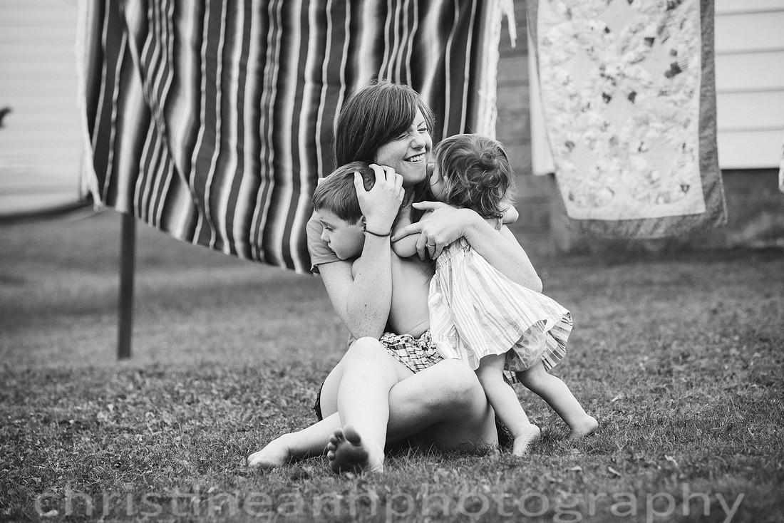 Duluth MN Lifestyle Family Session with a beloved teddy bear, apple tree, apples, sleepy kids, balloons, lawnmower, siblings, diaper, laundry, mom, dad - all outdoors in the back yard of their home.