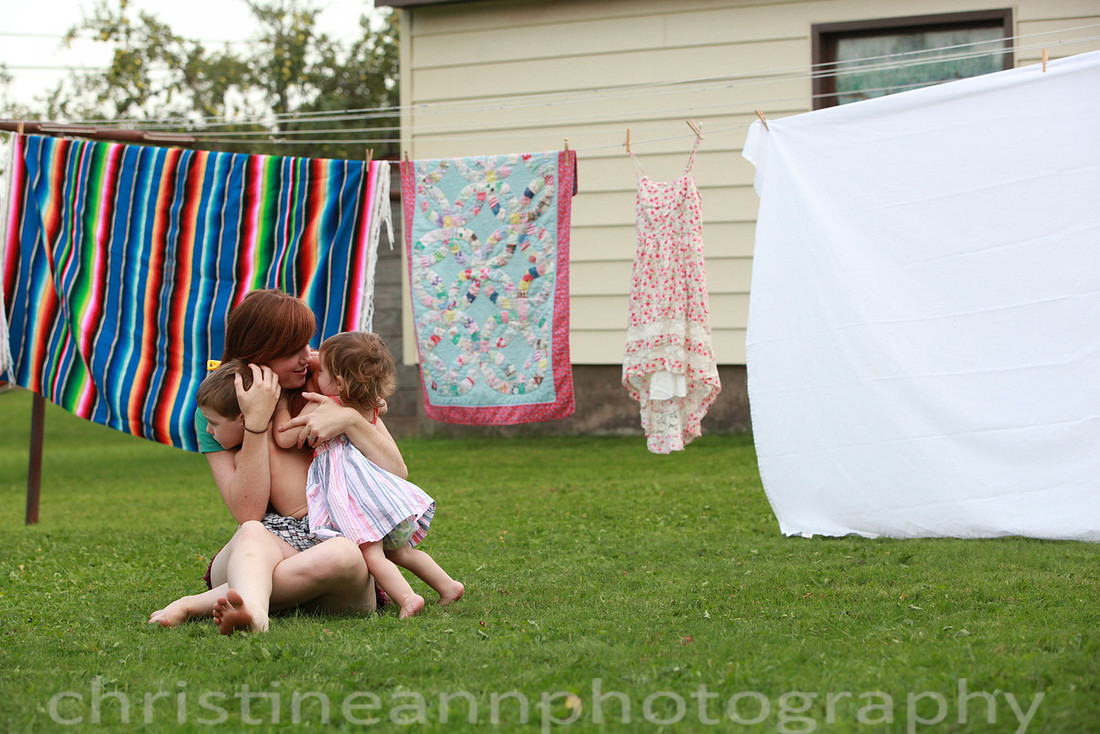 Duluth MN Lifestyle Family Session with a beloved teddy bear, apple tree, apples, sleepy kids, balloons, lawnmower, siblings, diaper, laundry, mom, dad - all outdoors in the back yard of their home.