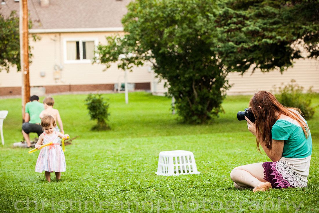 Duluth MN Lifestyle Family Session with a beloved teddy bear, apple tree, apples, sleepy kids, balloons, lawnmower, siblings, diaper, laundry, mom, dad - all outdoors in the back yard of their home.