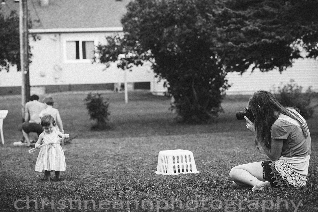 Duluth MN Lifestyle Family Session with a beloved teddy bear, apple tree, apples, sleepy kids, balloons, lawnmower, siblings, diaper, laundry, mom, dad - all outdoors in the back yard of their home.
